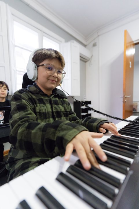 Estudiante sonriente en clase de piano
