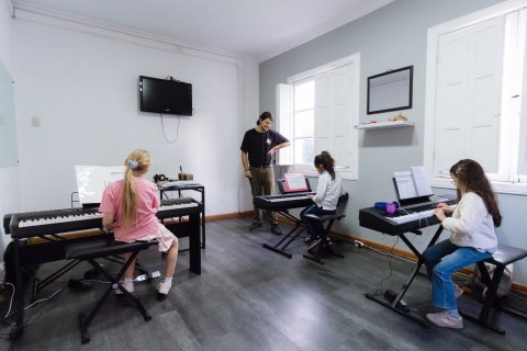 Clase grupal de piano para niños