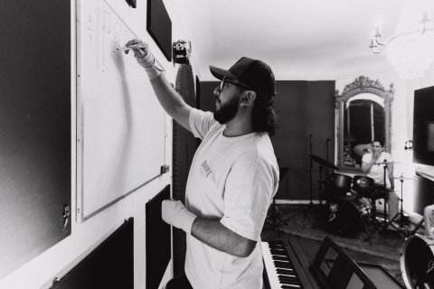 Profesor explicando teoría y ritmo musical en la pizarra